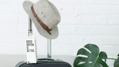 A hat and Boxed Water carton sit on a suitcase