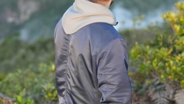 a man standing on top of a lush green hillside