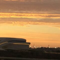a plane is flying in the sky at sunset