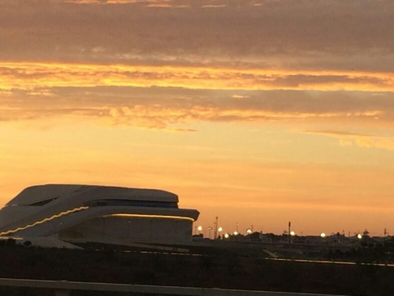 a plane is flying in the sky at sunset